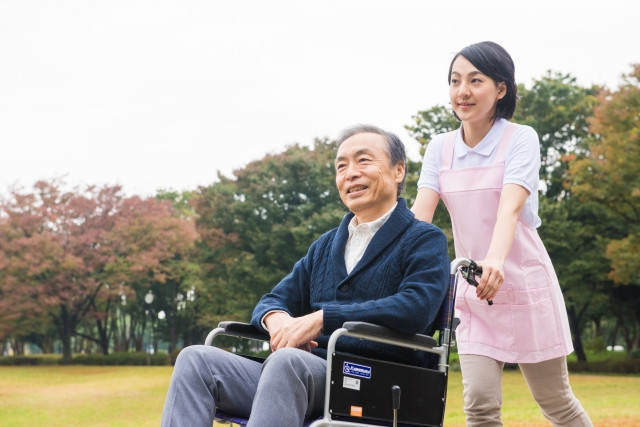 患者の乗った車いすと看護師